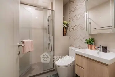 Modern bathroom with glass shower, sleek vanity, and stylish decor