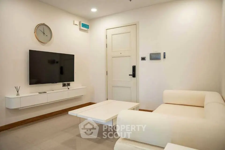 Modern living room with sleek furniture and wall-mounted TV, perfect for contemporary living.