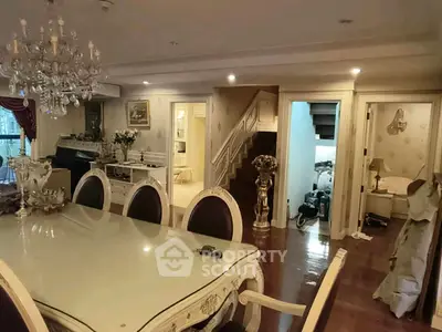 Elegant dining room with chandelier and classic decor, featuring a spacious layout and luxurious furnishings.