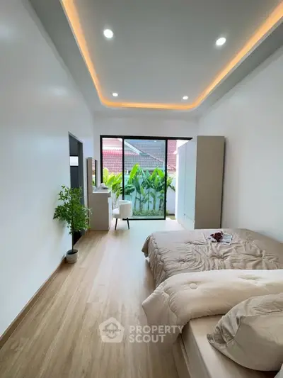 Spacious bedroom with modern design and garden view, featuring elegant lighting and cozy decor.