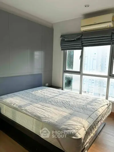 Spacious bedroom with large window and natural light in modern apartment