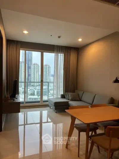 Modern living room with city view, featuring sleek furniture and large windows for natural light.