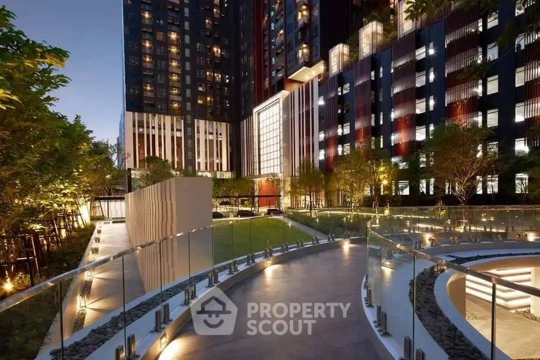 Stunning modern building exterior with illuminated pathway and lush greenery