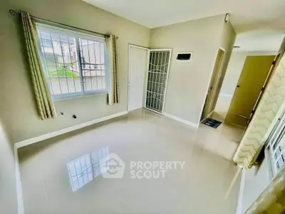 Spacious unfurnished room with large window and glossy tiled floor, perfect for customization.