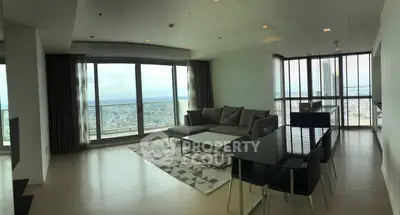 Spacious modern living room with panoramic city views and elegant furnishings.