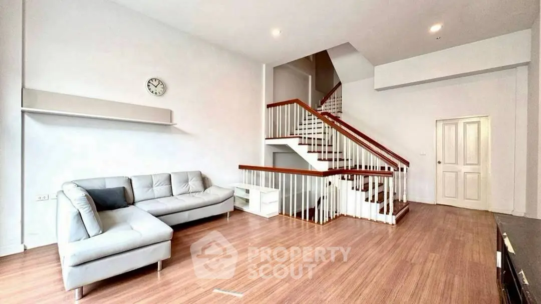 Spacious living room with modern staircase and cozy sectional sofa