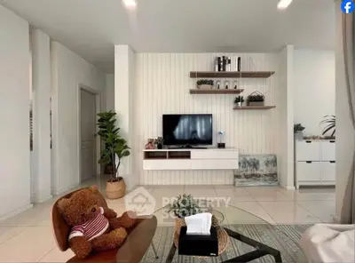 Modern living room with stylish decor, wall-mounted TV, and cozy seating area.