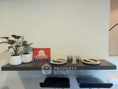 Modern minimalist dining setup with floating shelf and stylish decor.