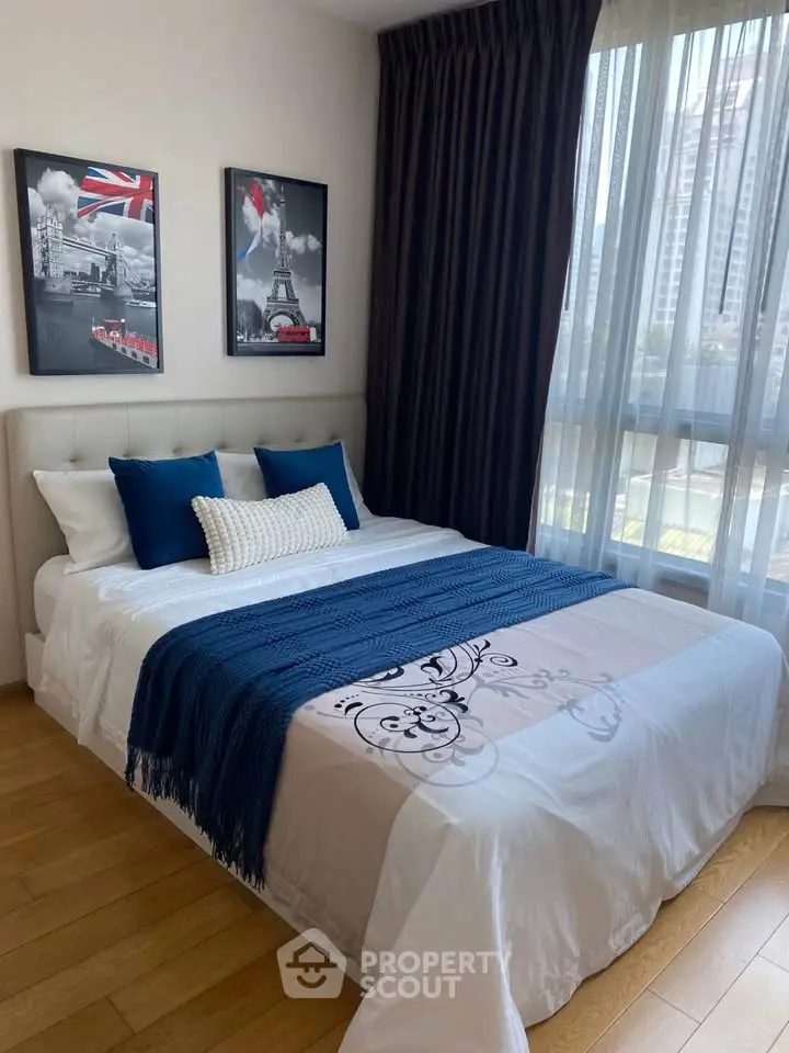 Elegant bedroom with large window and stylish decor in modern apartment.