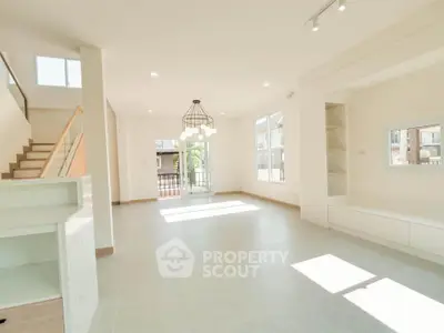 Spacious modern living room with natural light and elegant staircase