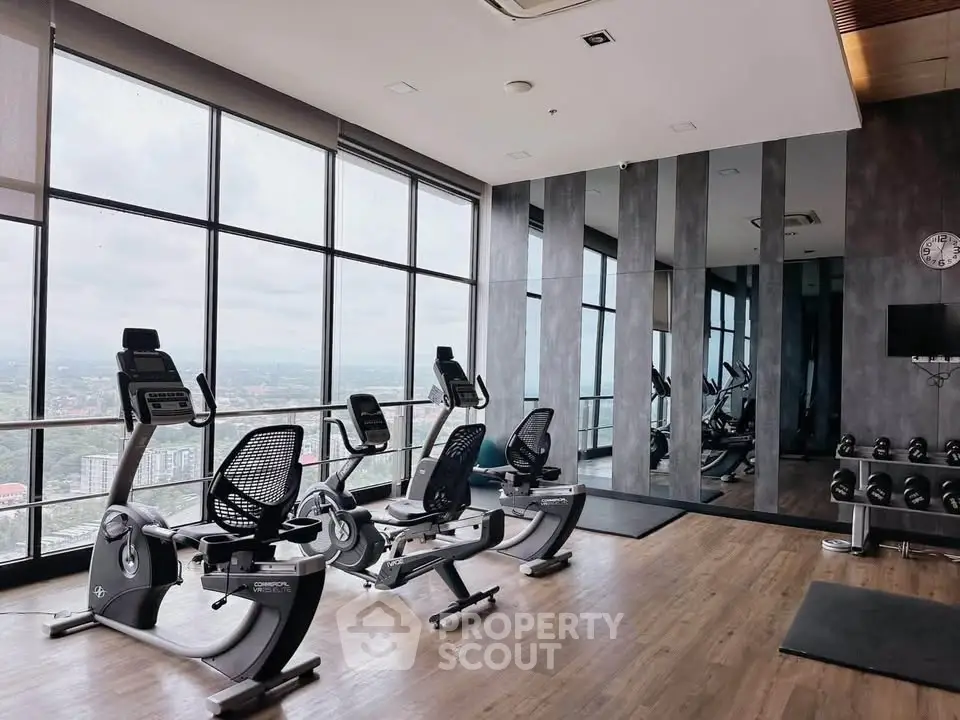 Modern gym with panoramic city views and state-of-the-art fitness equipment.