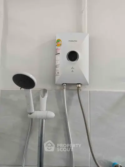 Modern bathroom with sleek shower and water heater installation.