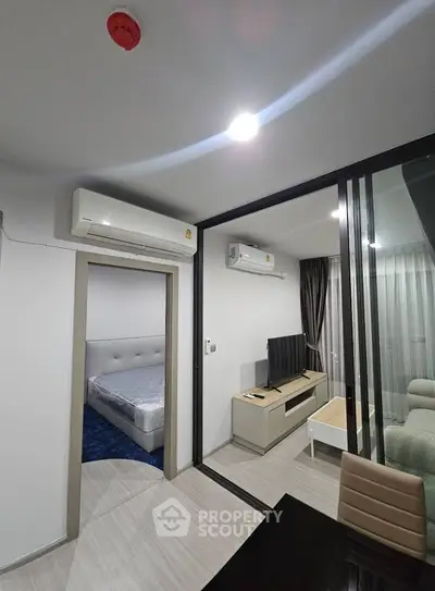 Modern apartment interior with sleek design, featuring a cozy living room and bedroom with air conditioning.