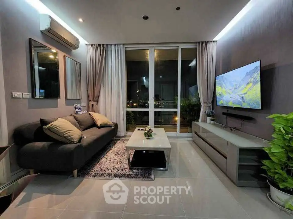 Modern living room with sleek design, large TV, and city view.