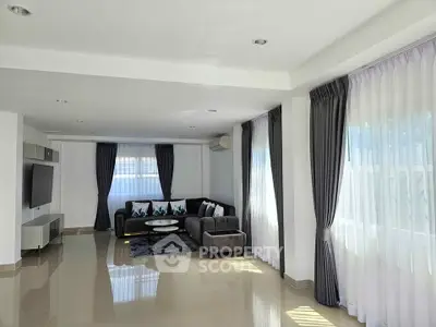 Spacious modern living room with elegant curtains and cozy seating area
