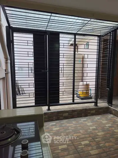 Modern kitchen with gas stove and outdoor view through metal grill