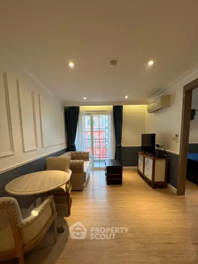 Charming living room with elegant decor and natural light, featuring cozy seating and a stylish TV unit.