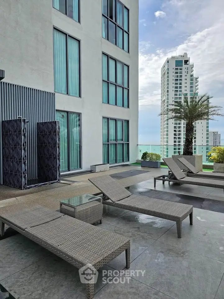 Luxurious rooftop terrace with modern lounge chairs and stunning city views.
