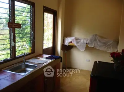 Cozy kitchen with natural light and garden view, featuring a compact layout and rustic charm.