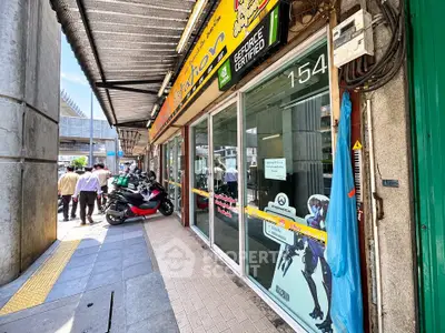 Street view of commercial property with glass storefront and vibrant signage.