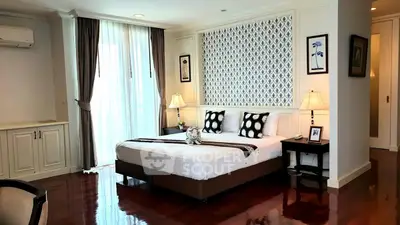 Luxurious bedroom with elegant decor and polished wooden floors in a modern apartment.
