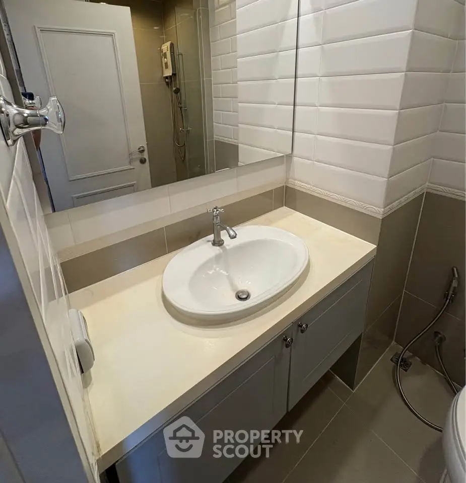 Modern bathroom with sleek sink and tiled walls, showcasing contemporary design and functionality.