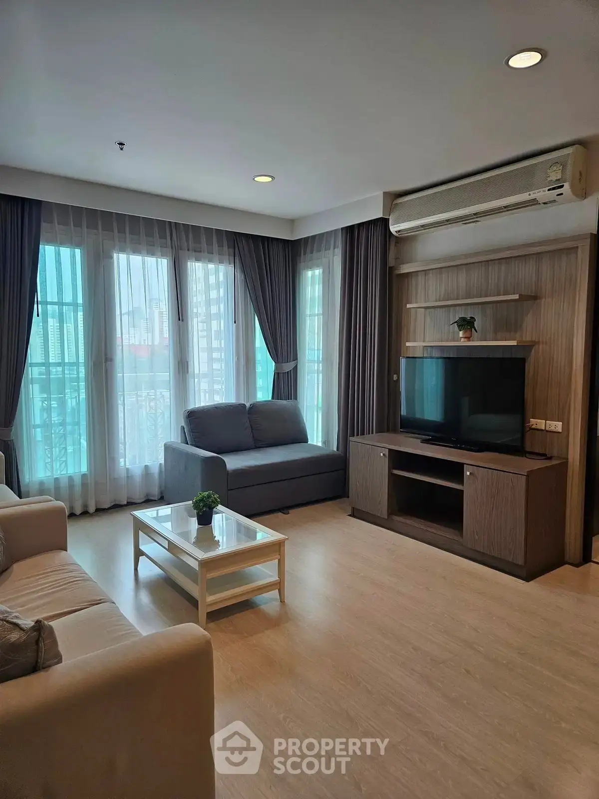 Spacious living room with modern furniture and large windows in a stylish apartment.
