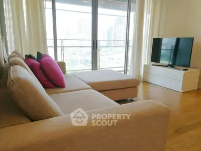 Spacious living room with modern sofa and city view balcony in high-rise apartment.