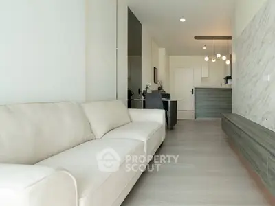 Modern living room with elegant sofa and open kitchen layout in stylish apartment.