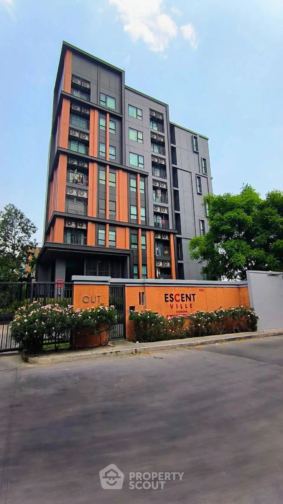 Modern multi-story residential building with vibrant facade and lush greenery, ideal for urban living.