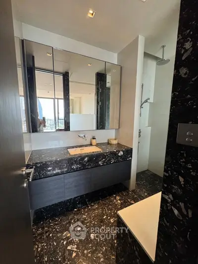 Luxurious modern bathroom with sleek black marble and elegant fixtures