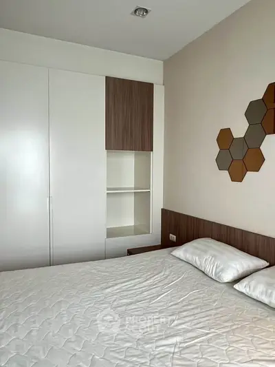 Modern bedroom with stylish geometric wall art and sleek built-in wardrobe.