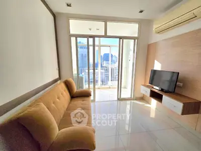 Bright living room with city view, modern sofa, and wall-mounted TV.