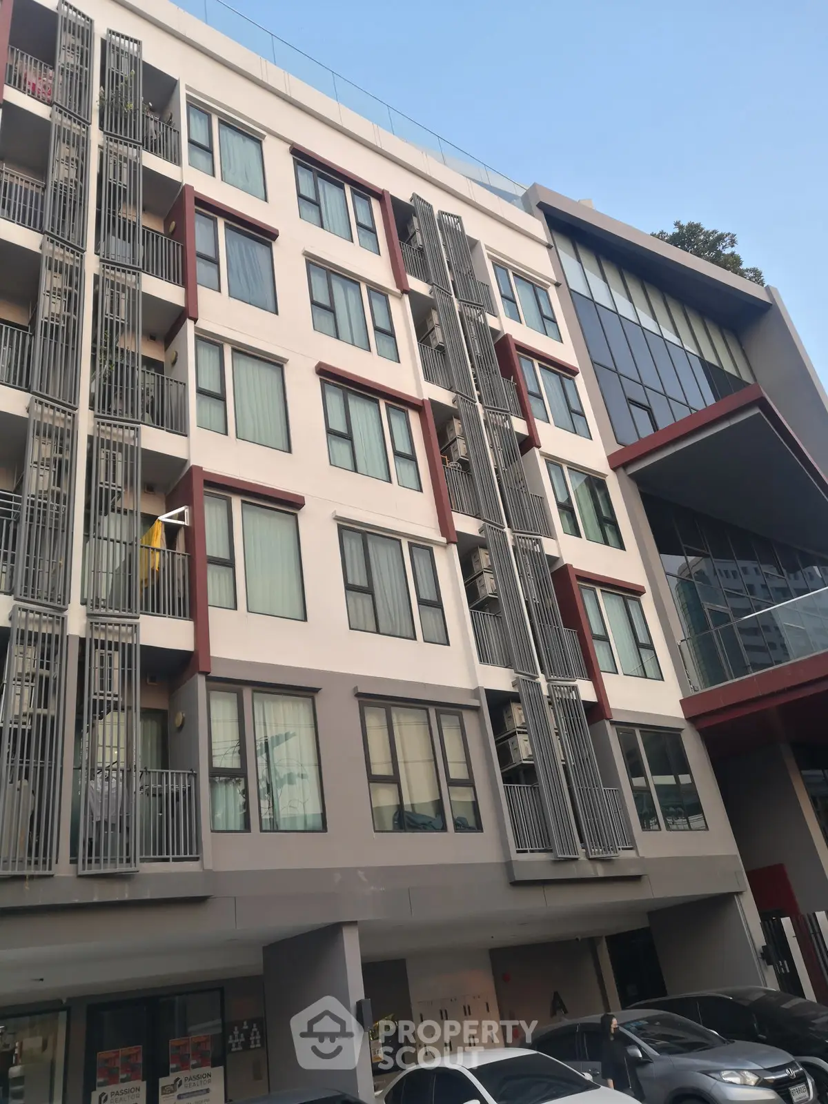 Modern multi-story apartment building with contemporary design and large windows.