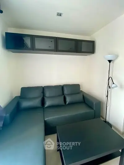 Cozy living room with modern black sofa and sleek storage cabinets.