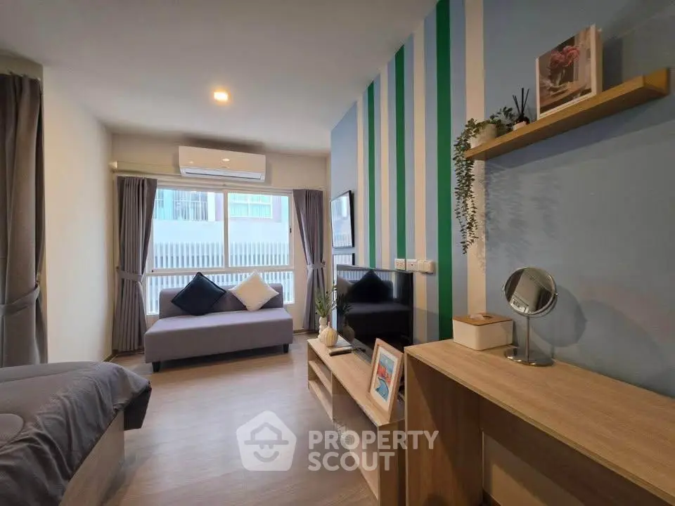 Modern living room with stylish decor and natural light, featuring a cozy sofa and sleek entertainment unit.