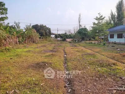 Spacious land plot with lush greenery and a small house, ideal for development or agriculture.