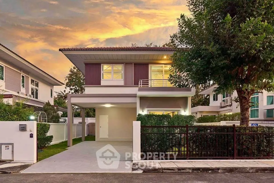 Charming two-story house with modern design and lush greenery at sunset.