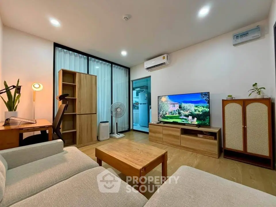 Modern living room with stylish furniture and large TV, featuring air conditioning and wooden accents.