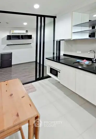 Modern kitchen with sleek design and open layout, featuring built-in appliances and stylish shelving.