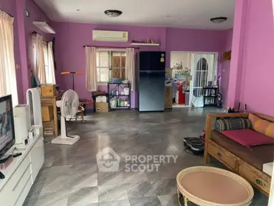 Spacious living room with purple walls and modern furnishings, featuring a large window and air conditioning.