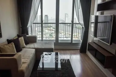 Modern living room with city view, featuring sleek furniture and large windows for natural light.