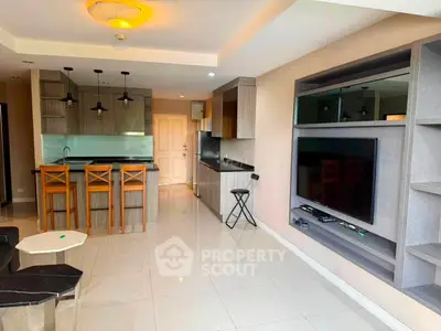 Modern open-layout living room with sleek kitchen and stylish entertainment center.