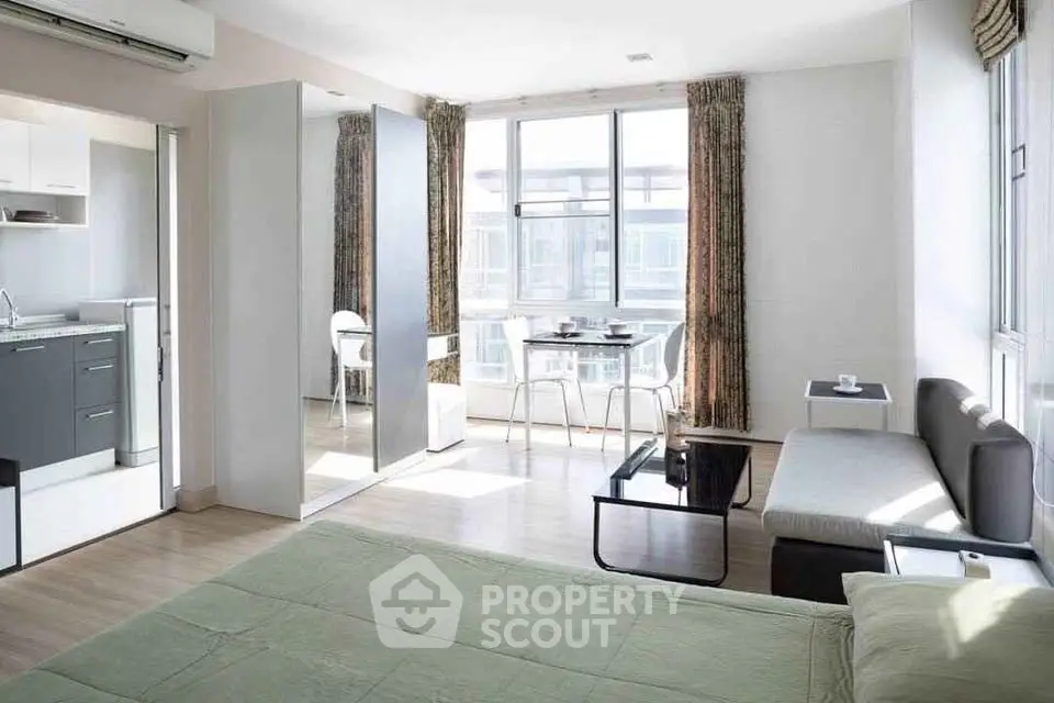 Modern studio apartment with open layout, featuring a cozy living area and compact kitchen.