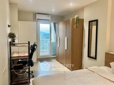 Modern bedroom with balcony view, featuring stylish furniture and natural light.