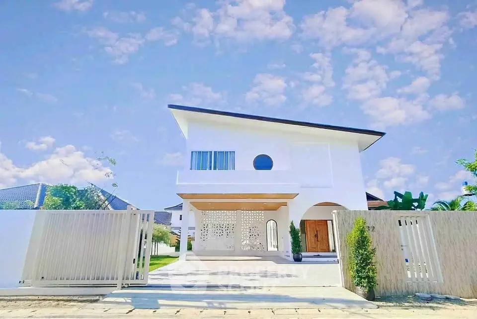 Stunning modern white house with unique architectural design and spacious driveway.