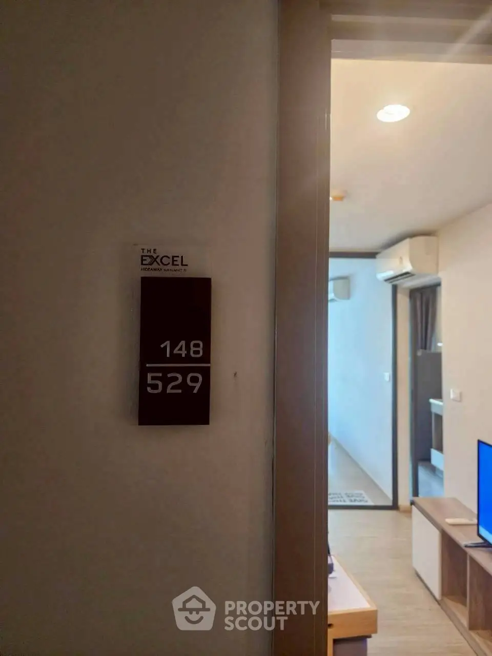 Modern apartment entrance with room number and glimpse of stylish interior