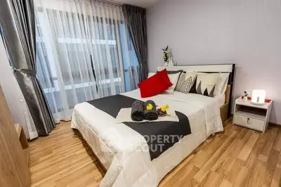 Modern bedroom with stylish decor and large window for natural light.