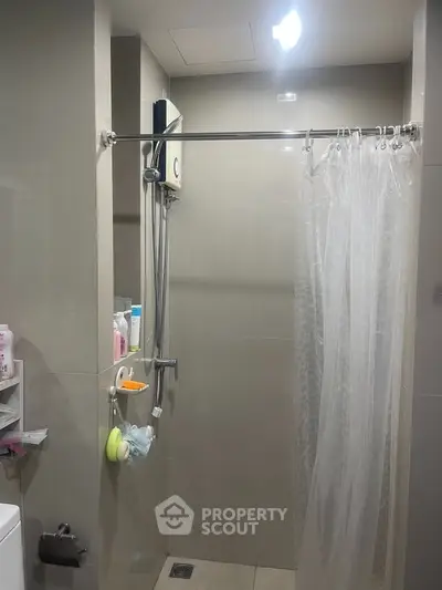 Modern bathroom with shower curtain and sleek fixtures in a contemporary home.