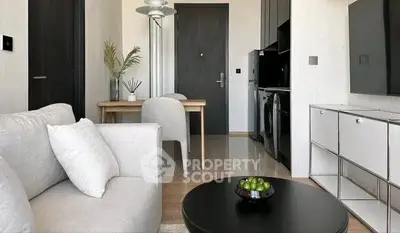 Modern living room with sleek kitchen, cozy seating, and stylish decor in a contemporary apartment.